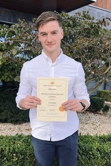 Aaron Bergin holding his coaching diploma.
